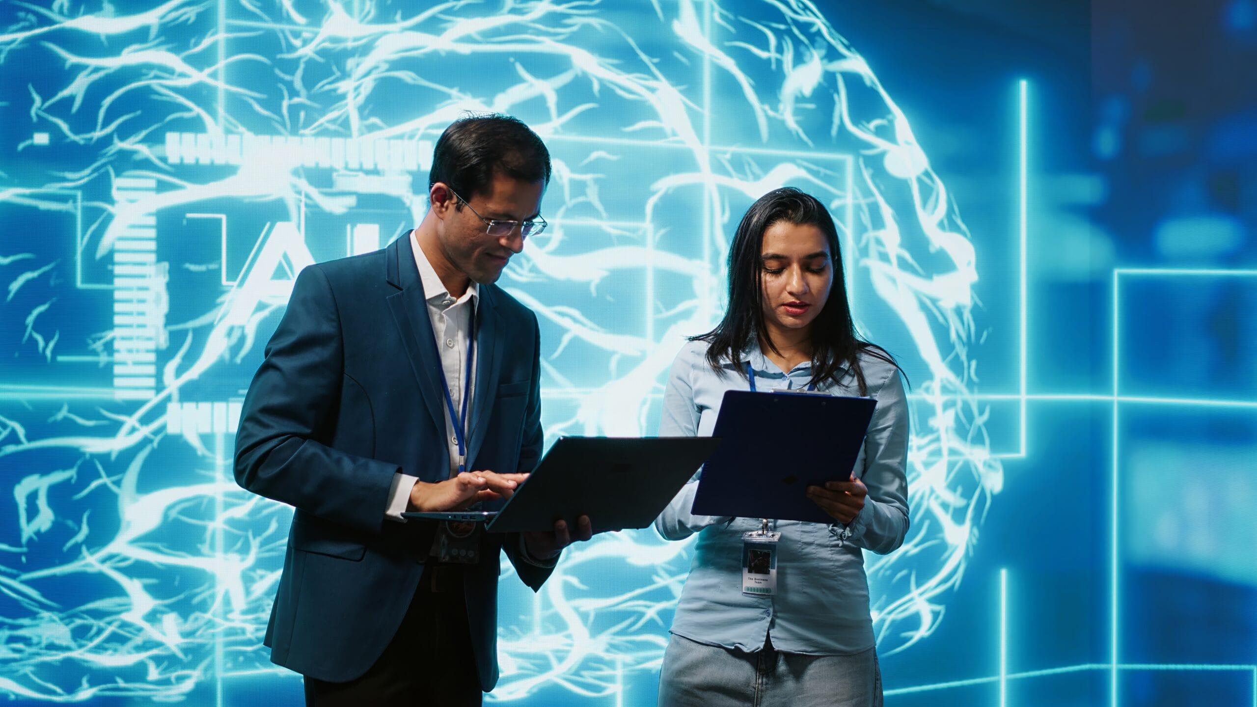 Computer scientists collaborating on developing AI system in high tech workspace