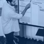 Agile vs Waterfall software delivery team reviewing a Waterfall Gantt chart and Agile sprint planning board on screen