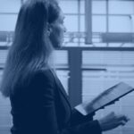Data platform engineer reviewing server racks on a tablet, representing Databricks metastore governance across a cloud region