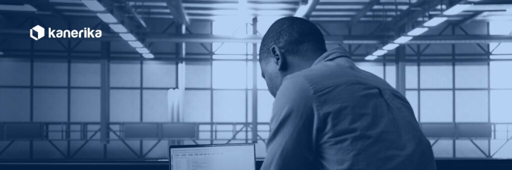 Data engineer reviewing ETL process optimization code on a laptop in a data center, Kanerika navy duotone hero banner