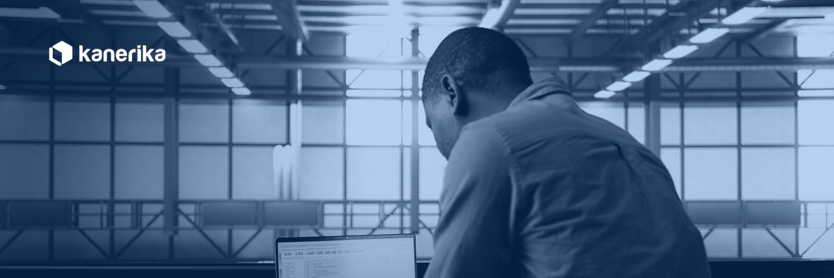 Data engineer reviewing ETL process optimization code on a laptop in a data center, Kanerika navy duotone hero banner