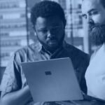 Kanerika banner for software development companies evaluation guide, engineers reviewing code together