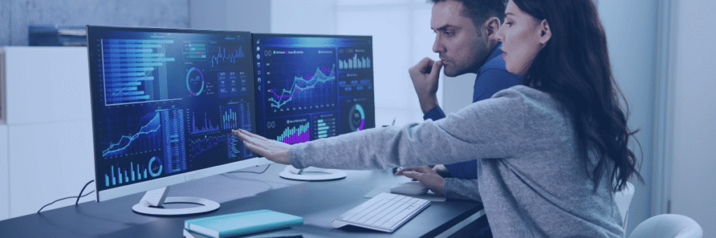 Kanerika vs. Tredence blog banner showing two data professionals reviewing analytics dashboards on office monitors.