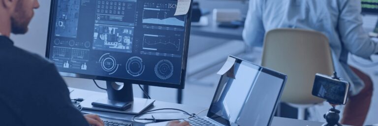 Kanerika vs. Fractal Analytics blog banner showing engineers working with enterprise data dashboards and system screens.