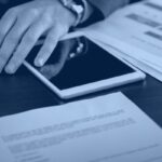 Microsoft Purview licensing cost analysis with a calculator, contract documents and a tablet on a desk, Kanerika blog banner