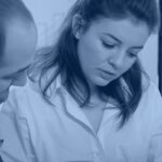 Two compliance professionals reviewing reports and a risk dashboard, illustrating AI governance risk and compliance oversight in an enterprise