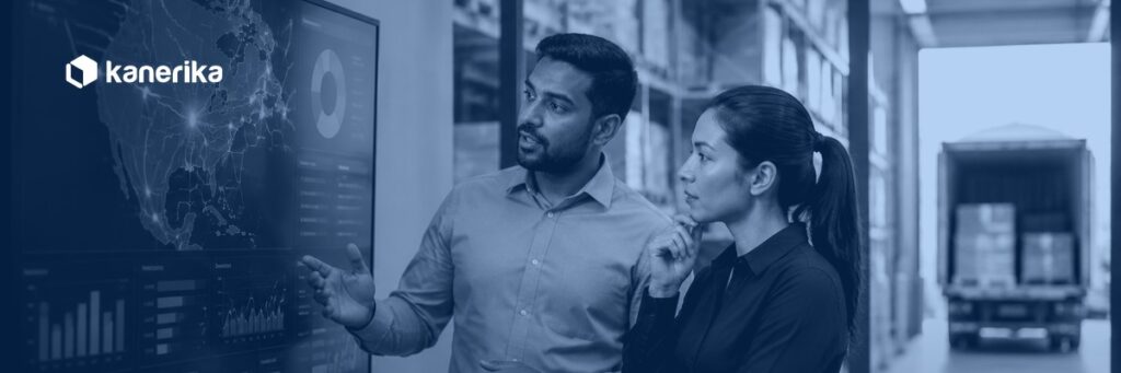 Custom software development for logistics, two analysts reviewing a shipment tracking dashboard in a warehouse with a delivery truck visible