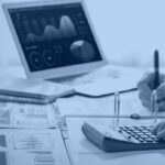 Analyst reviewing budget and BI dashboards while calculating Databricks cost optimization spend, Kanerika