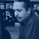 IT operations engineer reviewing generative AI incident alerts on monitoring dashboards in a data center