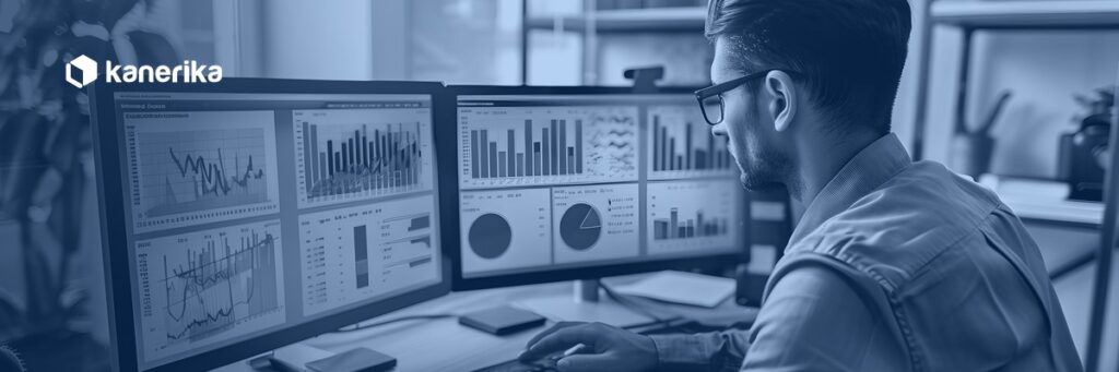 Data analyst reviewing multiple BI dashboards on dual monitors, representing a Snowflake semantic layer unifying metrics across tools