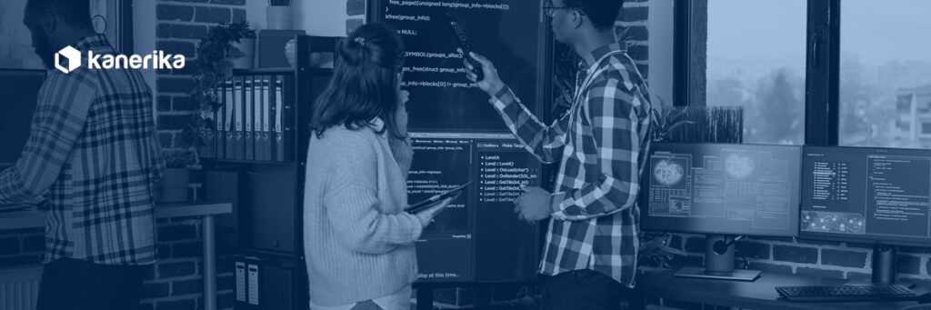Software engineering team reviewing code together in a navy-toned Kanerika banner for software development toolkit