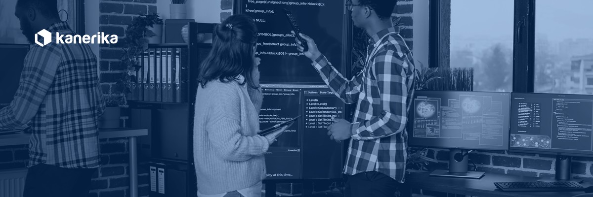 Software engineering team reviewing code together in a navy-toned Kanerika banner for software development toolkit
