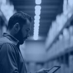Warehouse manager reviewing supply chain data on a tablet, representing supply chain master data management
