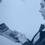 AI agent development cost banner showing an analyst working through a budget on a calculator at her desk