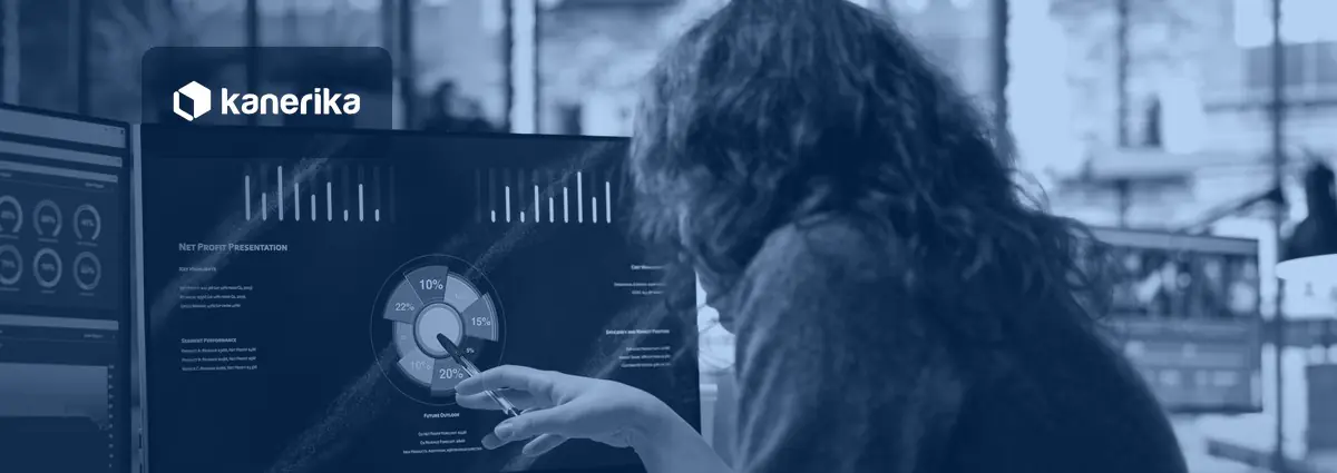 Analyst pointing at an AI performance metrics dashboard with charts on a monitor, Kanerika blog banner