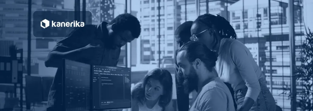 Software engineering team gathered around monitors reviewing code, representing engineering productivity tools for engineering leaders