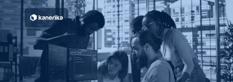 Software engineering team gathered around monitors reviewing code, representing engineering productivity tools for engineering leaders