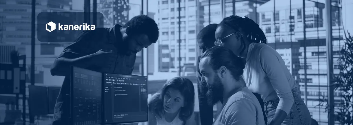 Software engineering team gathered around monitors reviewing code, representing engineering productivity tools for engineering leaders