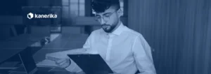 Analyst reviewing printed enterprise reports and charts, banner for Kanerika's guide to enterprise reporting tools