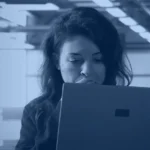 Generative AI security banner showing a security lead reviewing an AI threat alert on a laptop in a data center