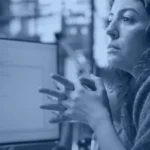 Software engineer reviewing code on a monitor, illustrating Jev AI use cases for enterprise decision automation