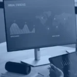 Analyst comparing a spreadsheet chart on a laptop with a business dashboard on a monitor, illustrating Power BI vs Excel for reporting