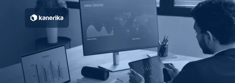 Analyst comparing a spreadsheet chart on a laptop with a business dashboard on a monitor, illustrating Power BI vs Excel for reporting