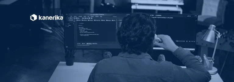 Software developer writing code on a dual-monitor setup, representing PySpark notebook development for Microsoft Fabric Warehouse