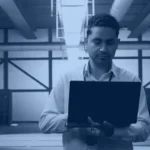 Engineer with a laptop in a data center planning SAP data migration tools and platform moves, Kanerika banner