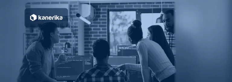 Software development team reviewing code and delivery metrics on monitors together, Kanerika blog banner for software development KPIs