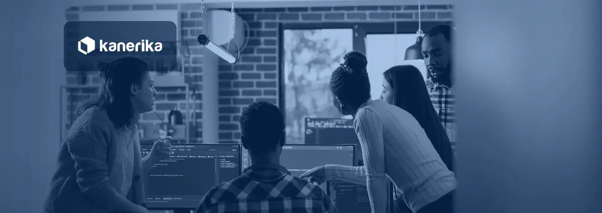 Software development team reviewing code and delivery metrics on monitors together, Kanerika blog banner for software development KPIs