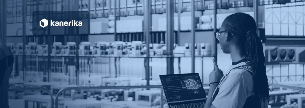 Engineer in a smart factory holding a laptop and looking out over robotic arms and production lines, Kanerika banner for agentic AI in manufacturing