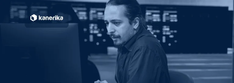 IT operations engineer investigating system errors at a workstation in a command center, navy-toned Kanerika banner for AIOps tools