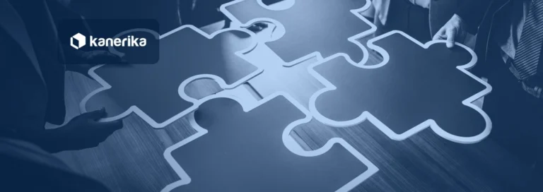 Team connecting large puzzle pieces on a table, navy-toned Kanerika banner for automated data integration