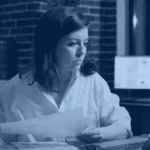 Professional reviewing business documents on a laptop in a dim office, Kanerika document intelligence blog banner