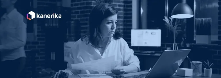Professional reviewing business documents on a laptop in a dim office, Kanerika document intelligence blog banner