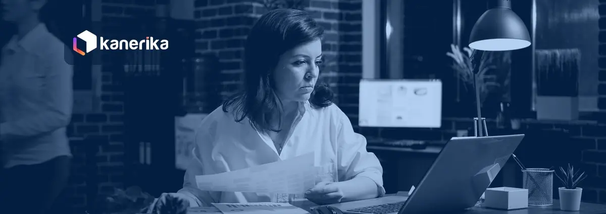 Professional reviewing business documents on a laptop in a dim office, Kanerika document intelligence blog banner