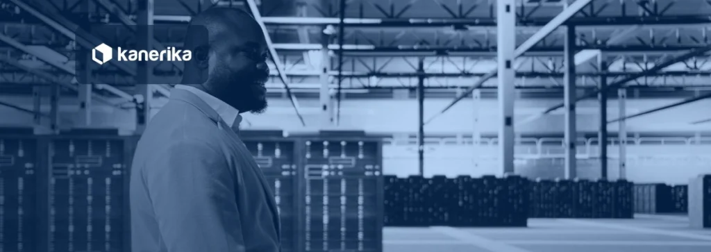Executive walking through a modern data center hall of server racks, navy-toned Kanerika banner for data center modernization