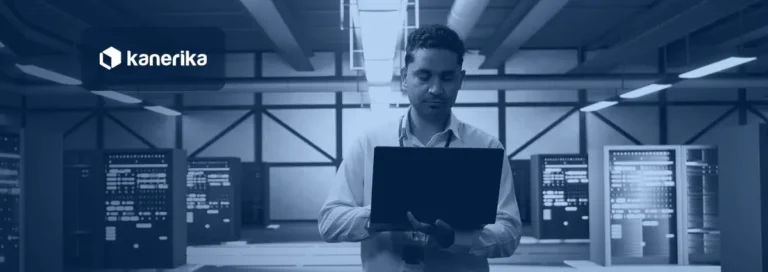 Technician holding a laptop between server racks in a data center, with Kanerika branding, for the 7 best data warehouse tools for enterprise analytics