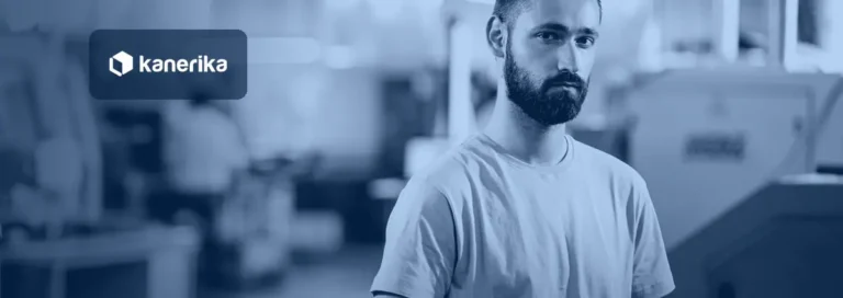 Young engineer holding a tablet on a factory floor beside CNC machines, representing generative AI use cases in manufacturing