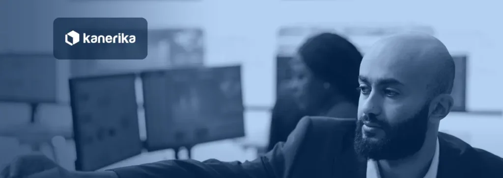Enterprise manager reviewing dashboards on several monitors in a monitoring room, illustrating oversight of an enterprise LLM