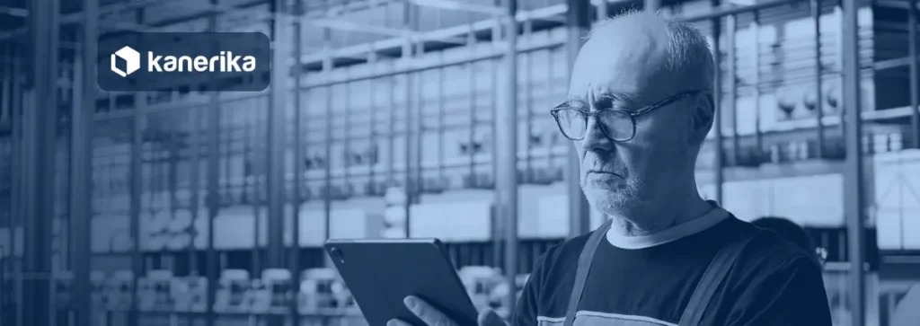 Plant engineer reviewing production data on a tablet in a factory, banner image for the Kanerika guide to manufacturing data analytics