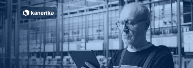 Plant engineer reviewing production data on a tablet in a factory, banner image for the Kanerika guide to manufacturing data analytics