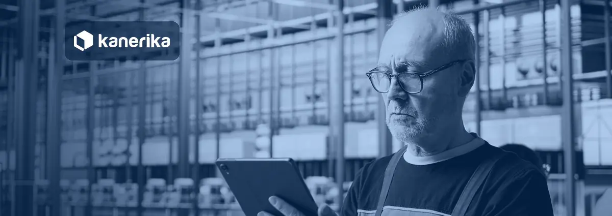 Plant engineer reviewing production data on a tablet in a factory, banner image for the Kanerika guide to manufacturing data analytics