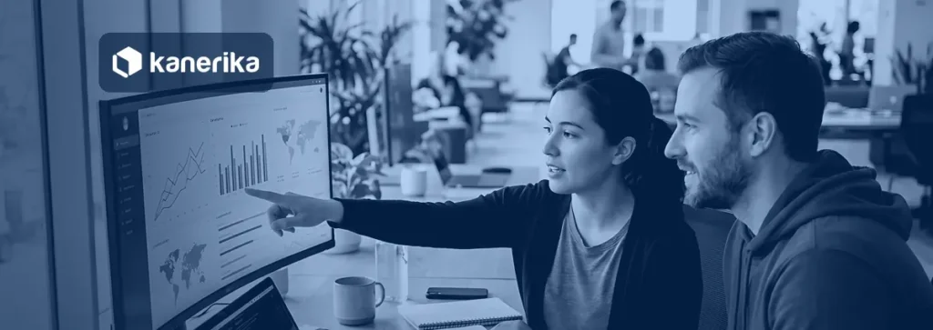 Two colleagues reviewing a data dashboard on a curved monitor, Kanerika banner for Rayfin vs Fabric Apps vs Power BI vs Power Apps