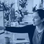 Two colleagues reviewing a data dashboard on a curved monitor, Kanerika banner for Rayfin vs Fabric Apps vs Power BI vs Power Apps