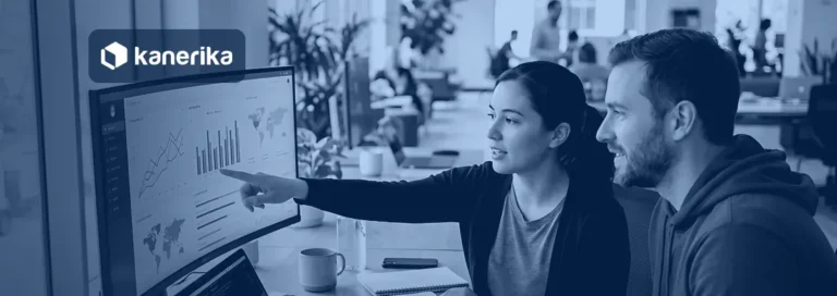 Two colleagues reviewing a data dashboard on a curved monitor, Kanerika banner for Rayfin vs Fabric Apps vs Power BI vs Power Apps