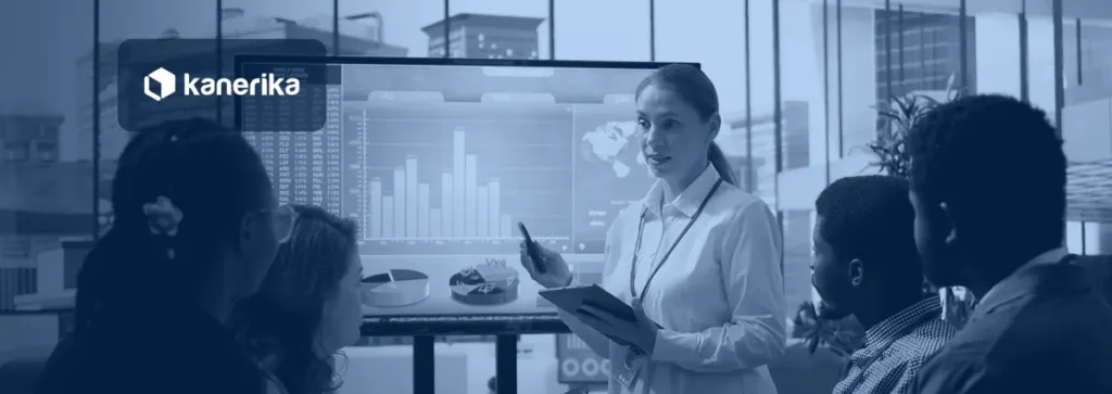 Kanerika blog banner for Microsoft Fabric workspaces, showing a team reviewing an analytics dashboard together in a meeting room