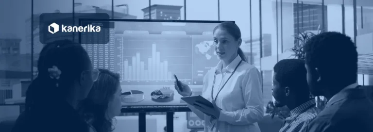 Kanerika blog banner for Microsoft Fabric workspaces, showing a team reviewing an analytics dashboard together in a meeting room