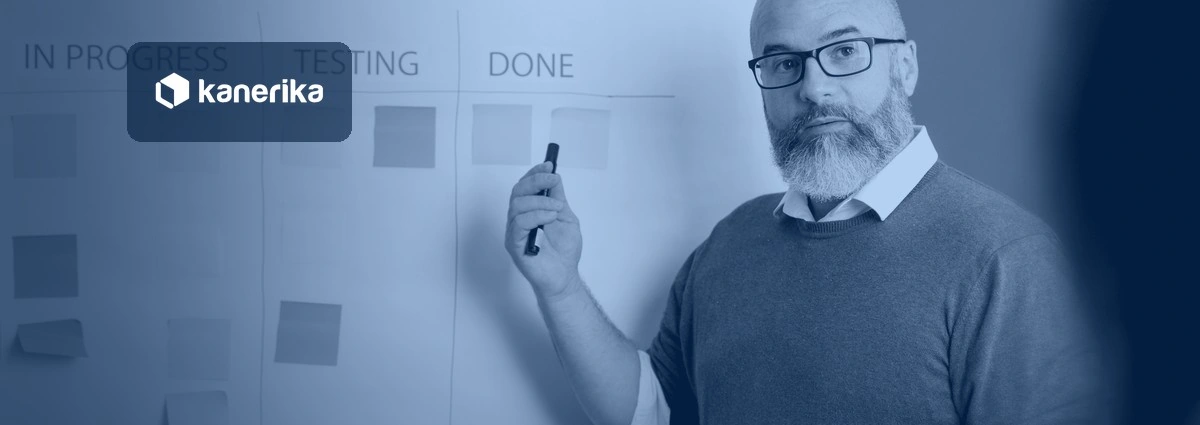 Man pointing to a kanban board of sticky notes (in progress, testing, done), representing process intelligence, shown in a navy blue tint with the Kanerika logo